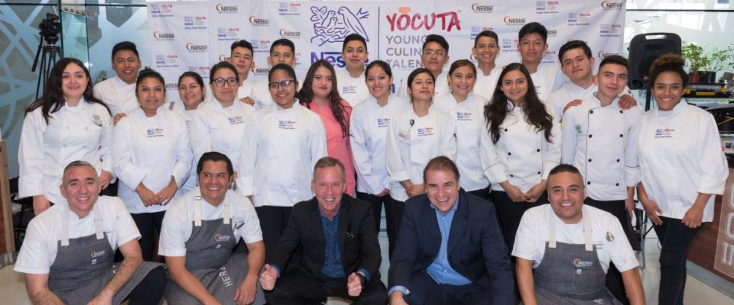 Un grupo de jóvenes con mandil blanco en la inauguración del programa Yocuta de NESTLÉ®