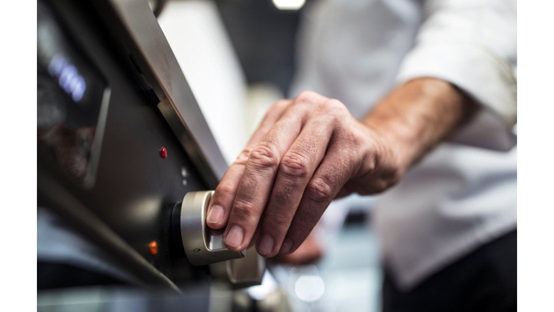 Chef manipulando la estufa de una cocina industrial