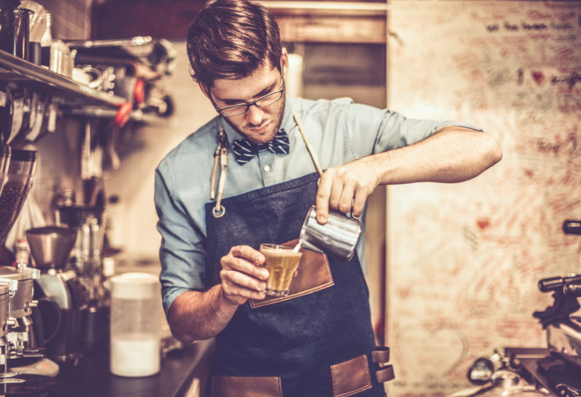 Joven barista preparando un café