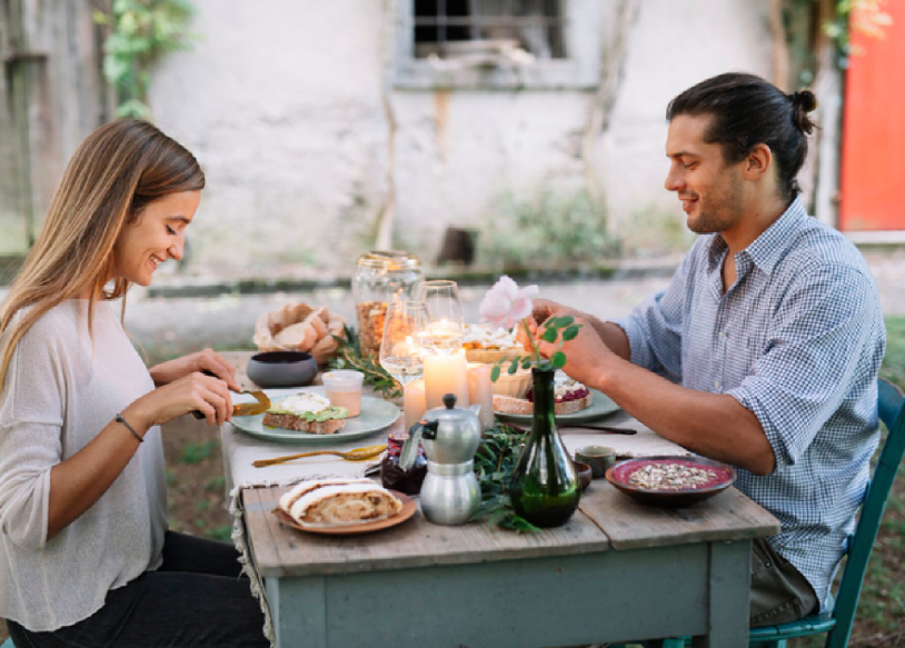Pareja disfrutando de una cena romántica en un restaurante al aire libre