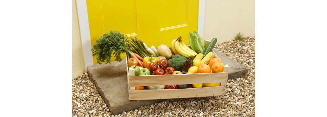Productos de mercados locales empacados en una caja de madera