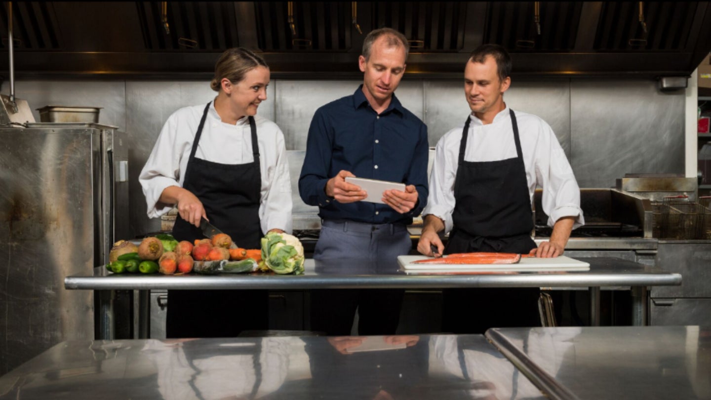 Chefs y gerente de inventario gestionando órdenes de compra