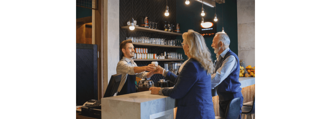 Hombre atendiendo a clientes de su cafetería