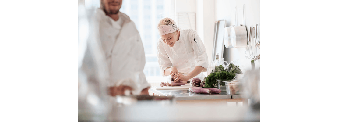 Mujer elaborando platos en una cocina profesional