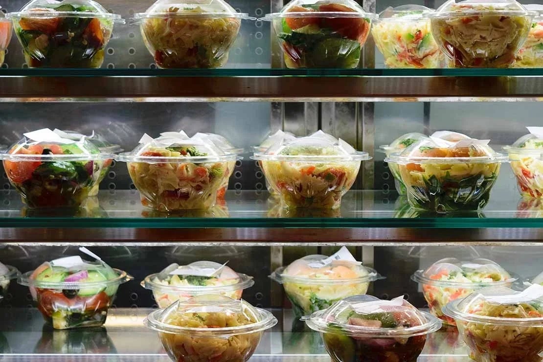 Varios alimentos frescos almacenados en recipientes herméticos en un refrigerador