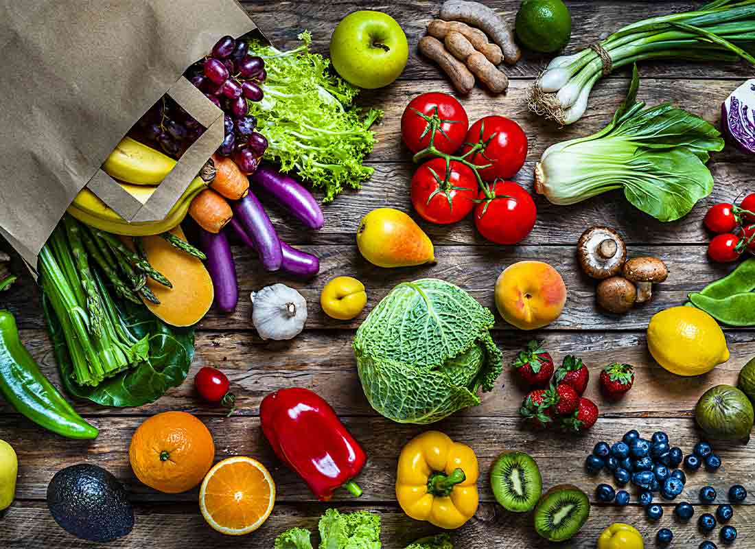 Frutas y verduras de temporada saliendo de una bolsa de papel