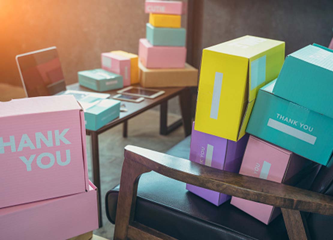 Empaques coloridos con el mensaje “thank you” puestos en la oficina de un negocio para hacer entregas a domicilio de postres