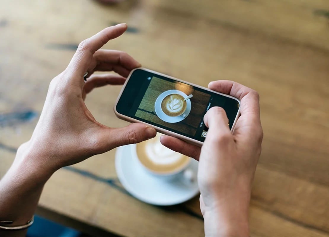 Persona toma foto con su smartphone para el plan de marketing gastronómico de su cafetería