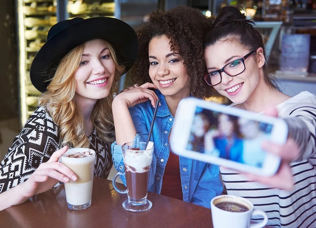 Tres influencers se toman fotos para sus redes sociales en una cafetería que aporta a un plan de marketing gastronómico