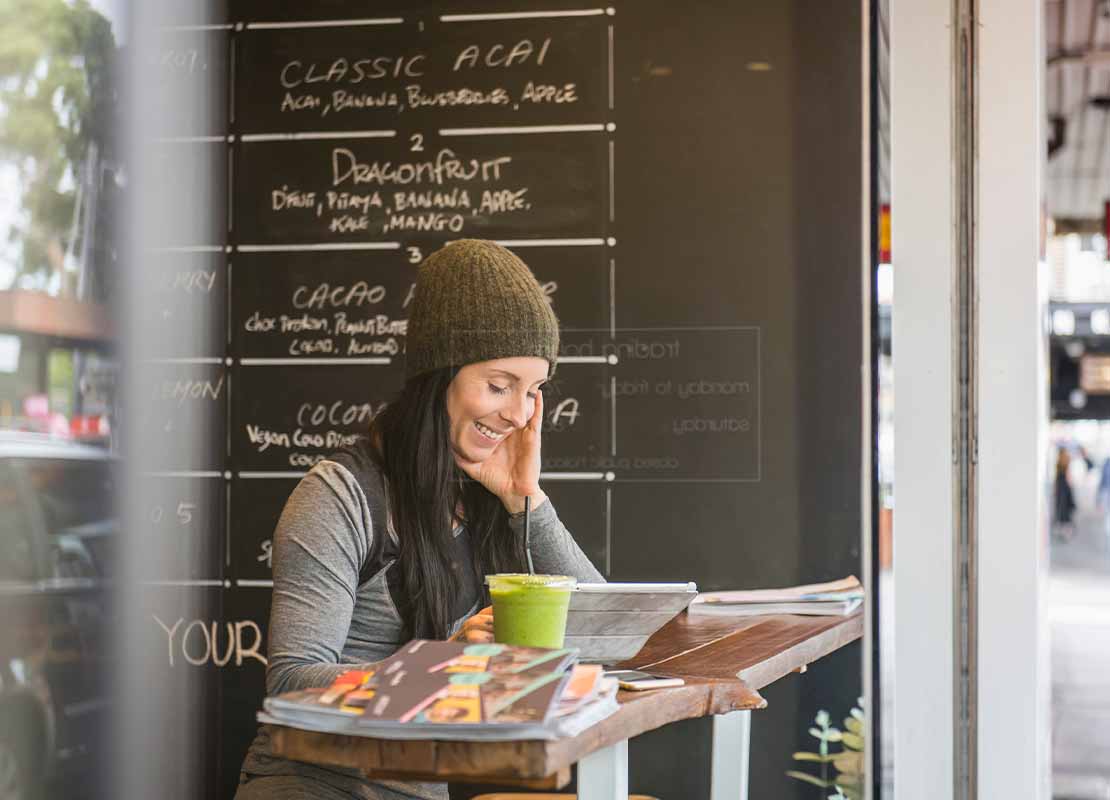 Cliente feliz revisa el menú de restaurante digitalizado en una Tablet