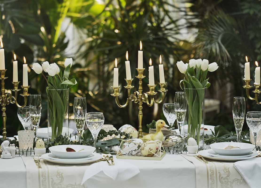 Velas, cubiertos y flores en un comedor de un restaurante temático que transmite frescura y conecta con la naturaleza