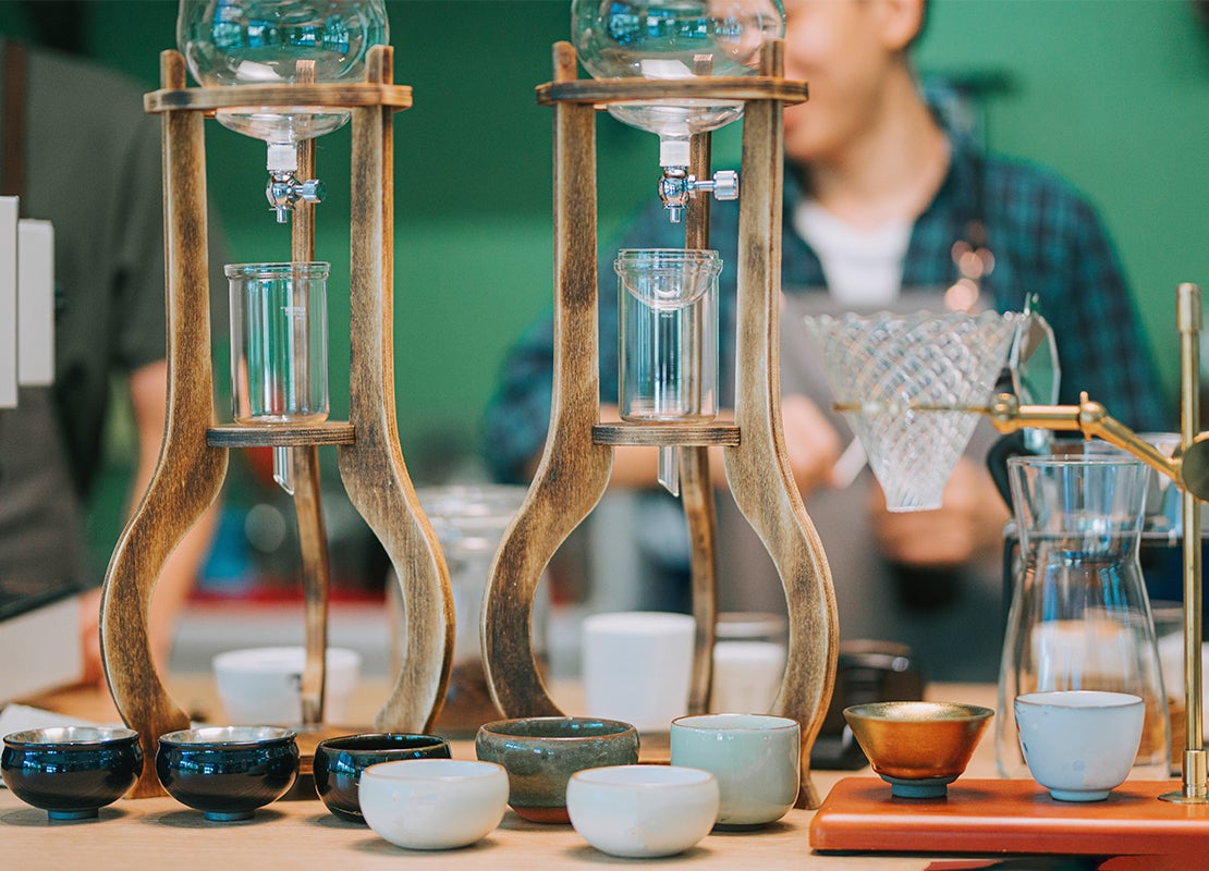 Tubos de ensayo, tazas de té y otros elementos para preparar café por goteo en un coffee lab