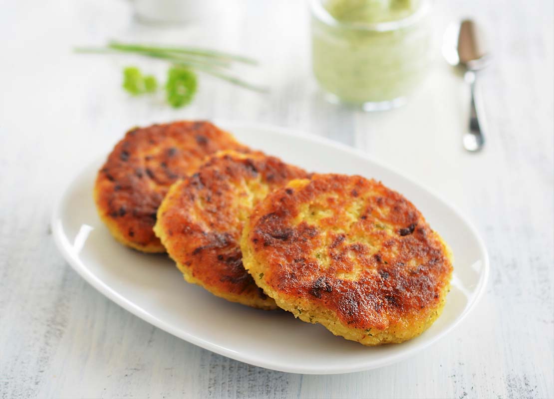 Sobre un plato blanco, 3 rodajas de proteína vegetal para hamburguesa elaboradas con garbanzo