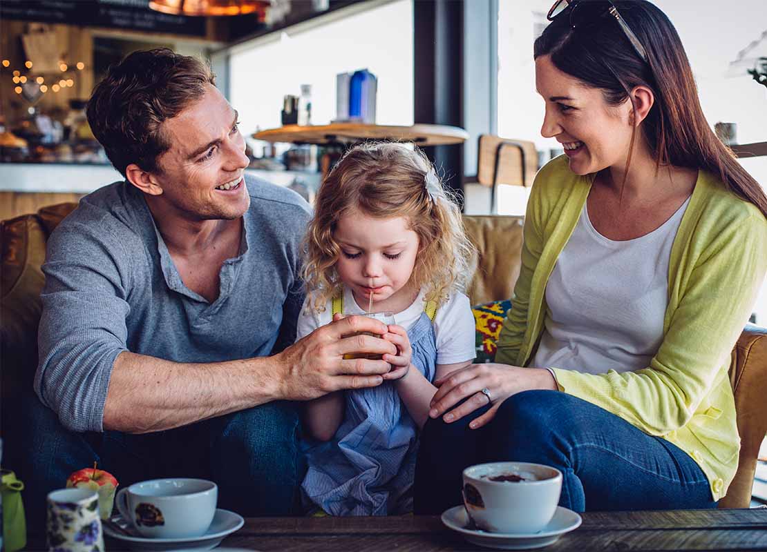 Familia en una cafetería disfruta de una taza de café para celebrar el Día del Padre