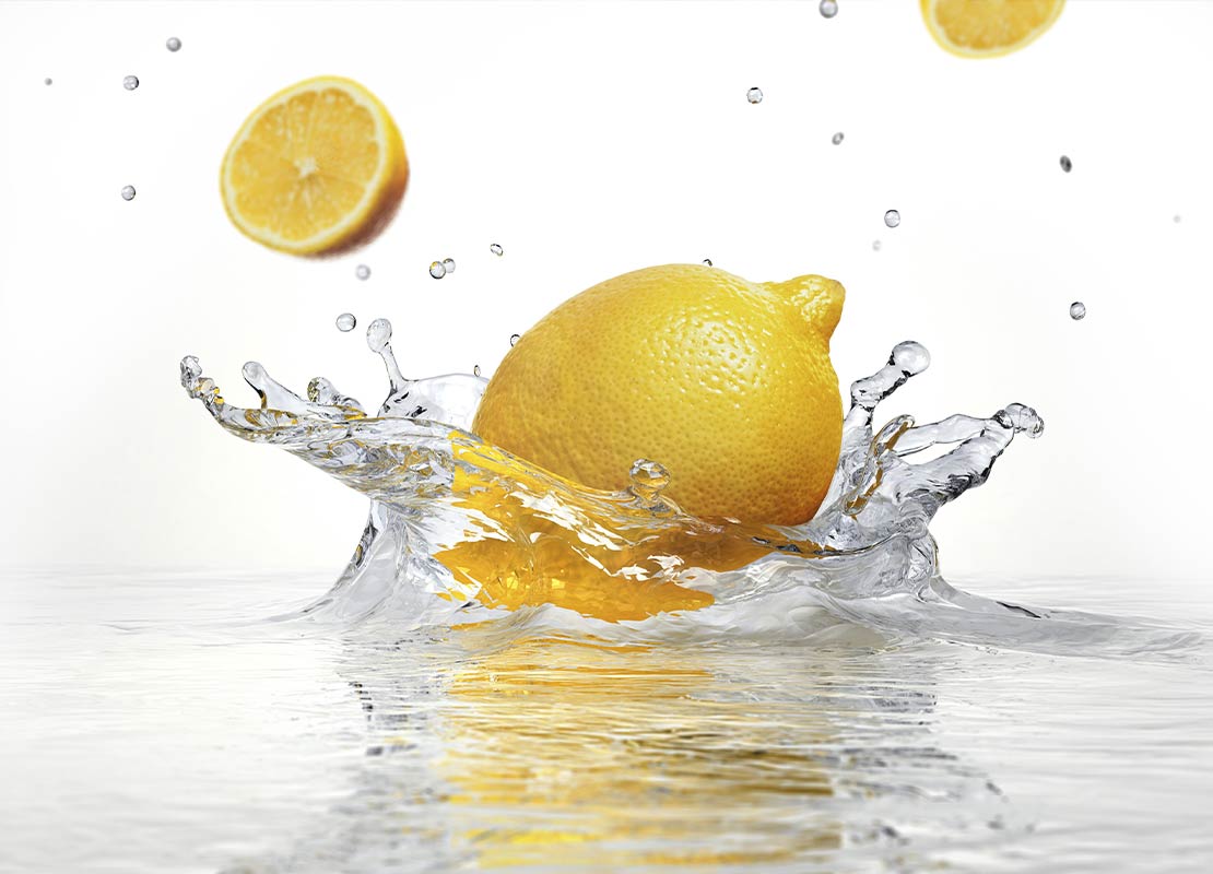 Un limón cae al agua haciendo splash, representa cómo se desinfectar frutas y verduras