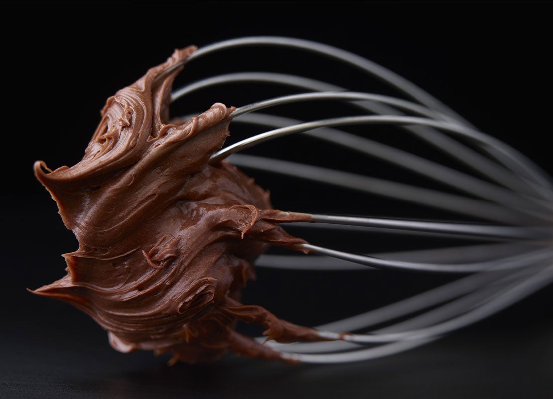 Chocolate para repostería adherido de un batidor manual