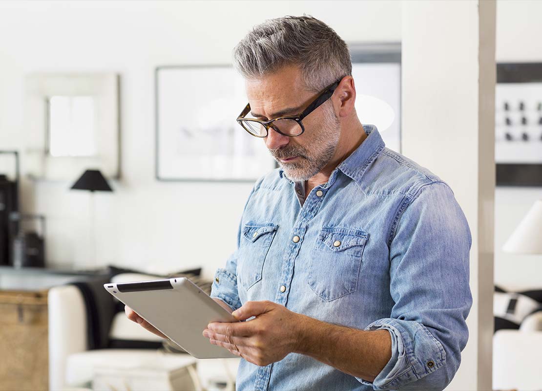 Emprendedor en su oficina revisa el presupuesto en una tablet para poner una cafetería