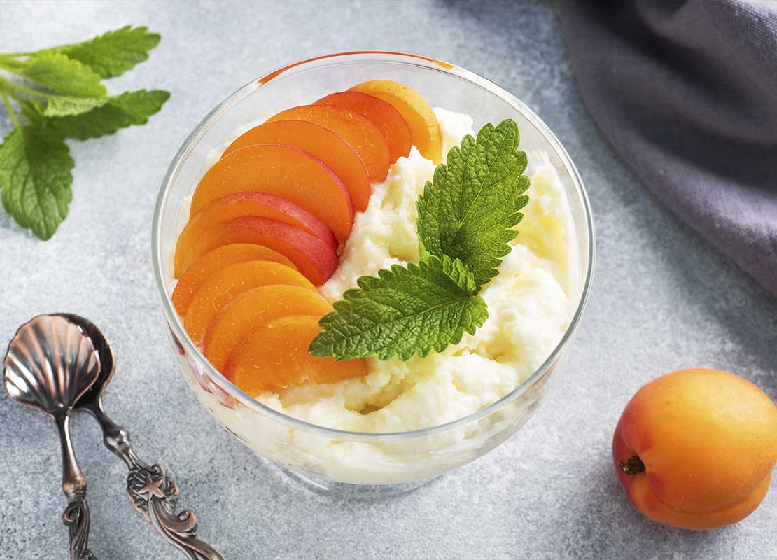 Una preparación de helado, duraznos y hierbabuena que hace parte de un menú de postres