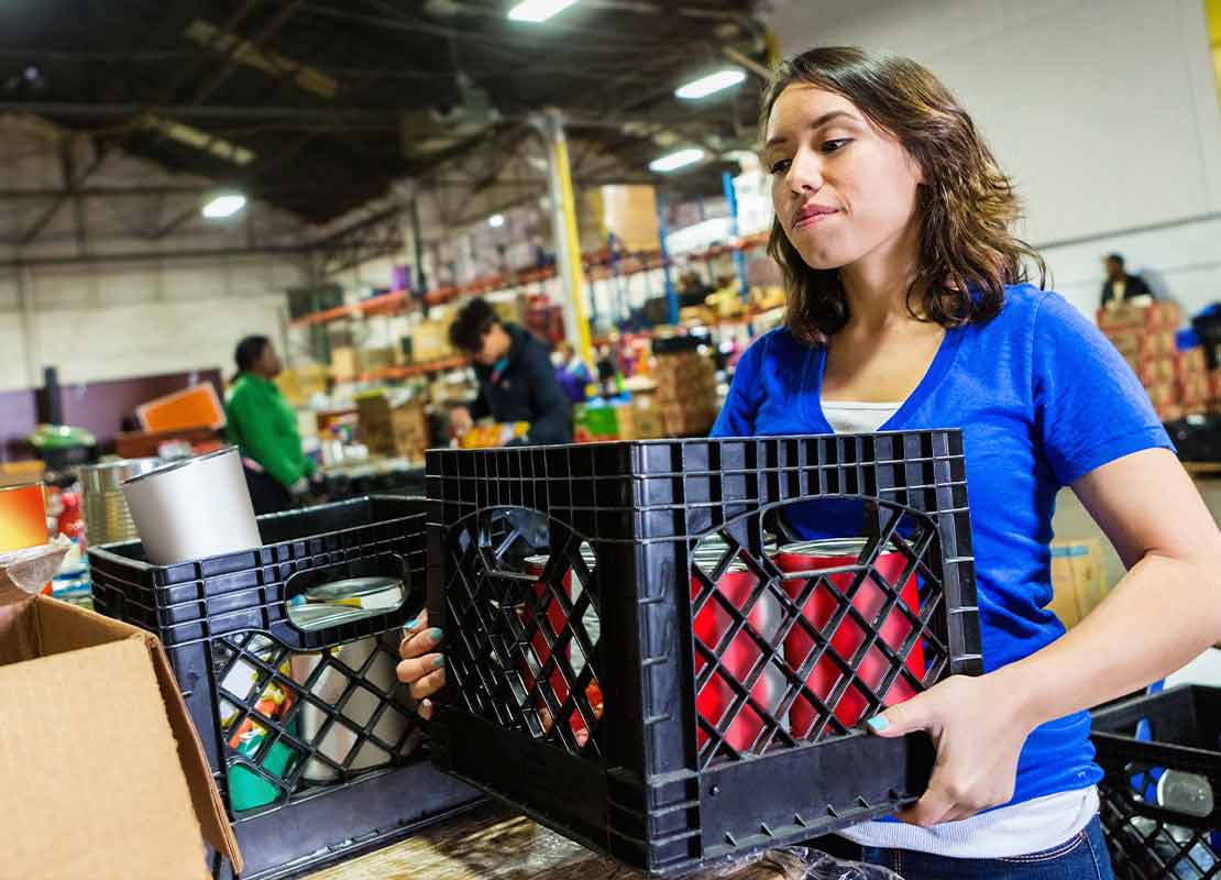 Emprendedora cargando caja con mercancía para su negocio de food service