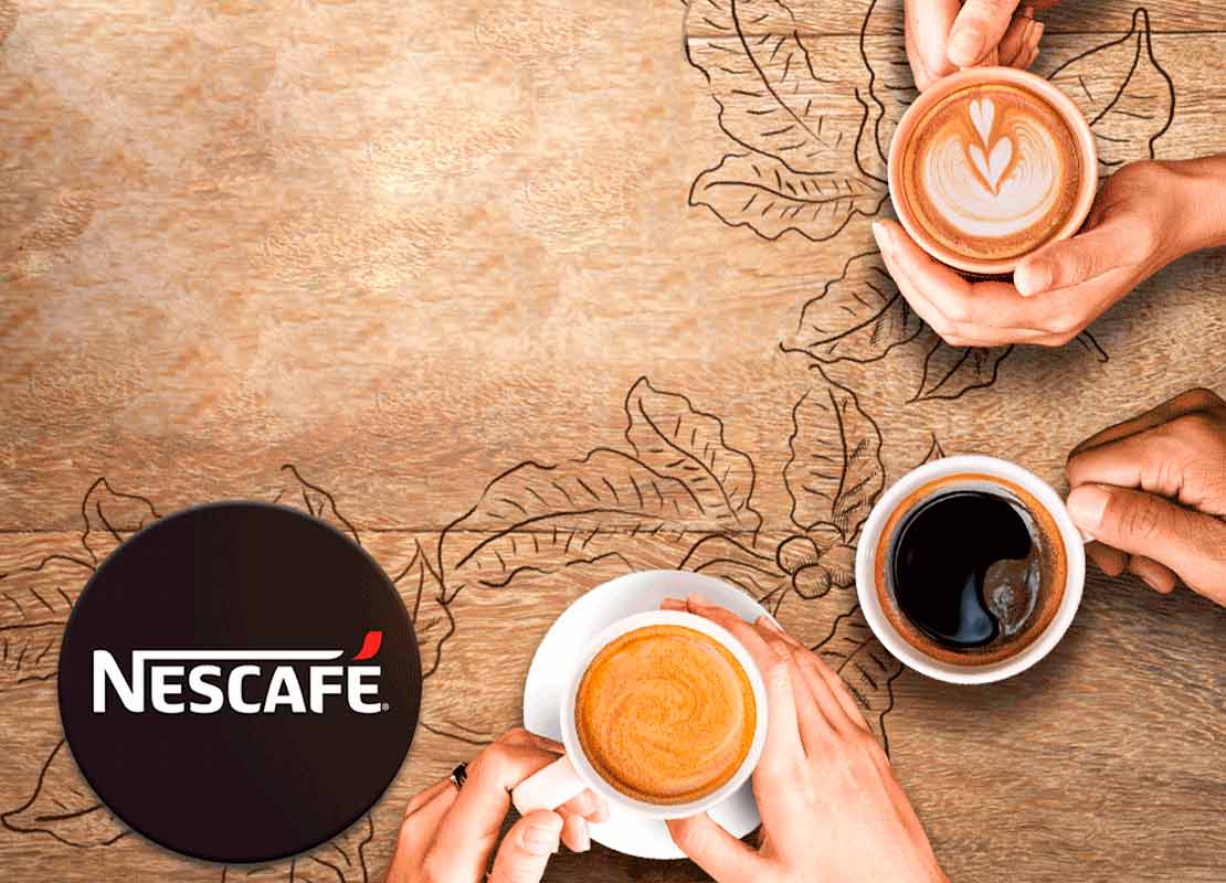 Manos sostienen 3 tazas de diferentes bebidas de café NESCAFÉ® para acompañar snacks para cafetería