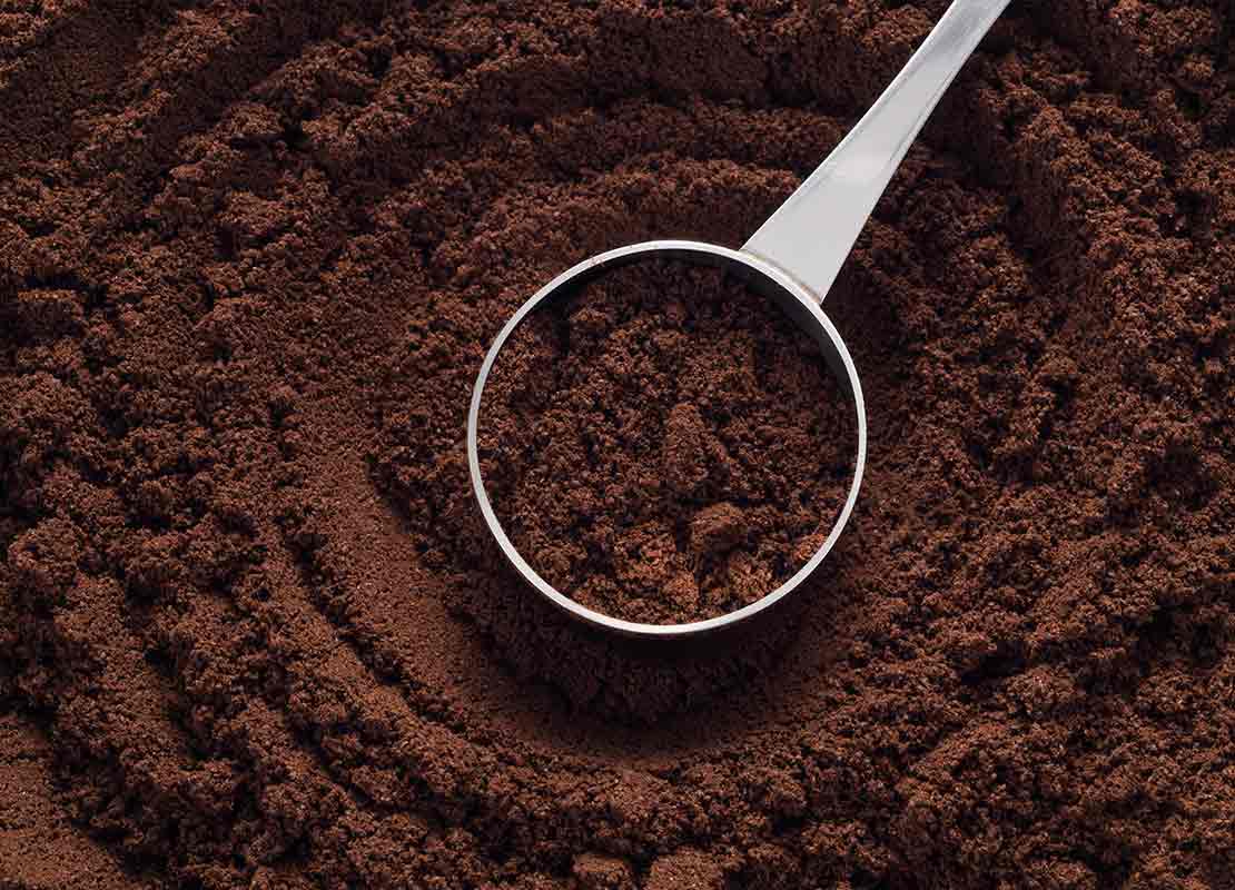 Café molido en cucharilla medidora de acero inoxidable