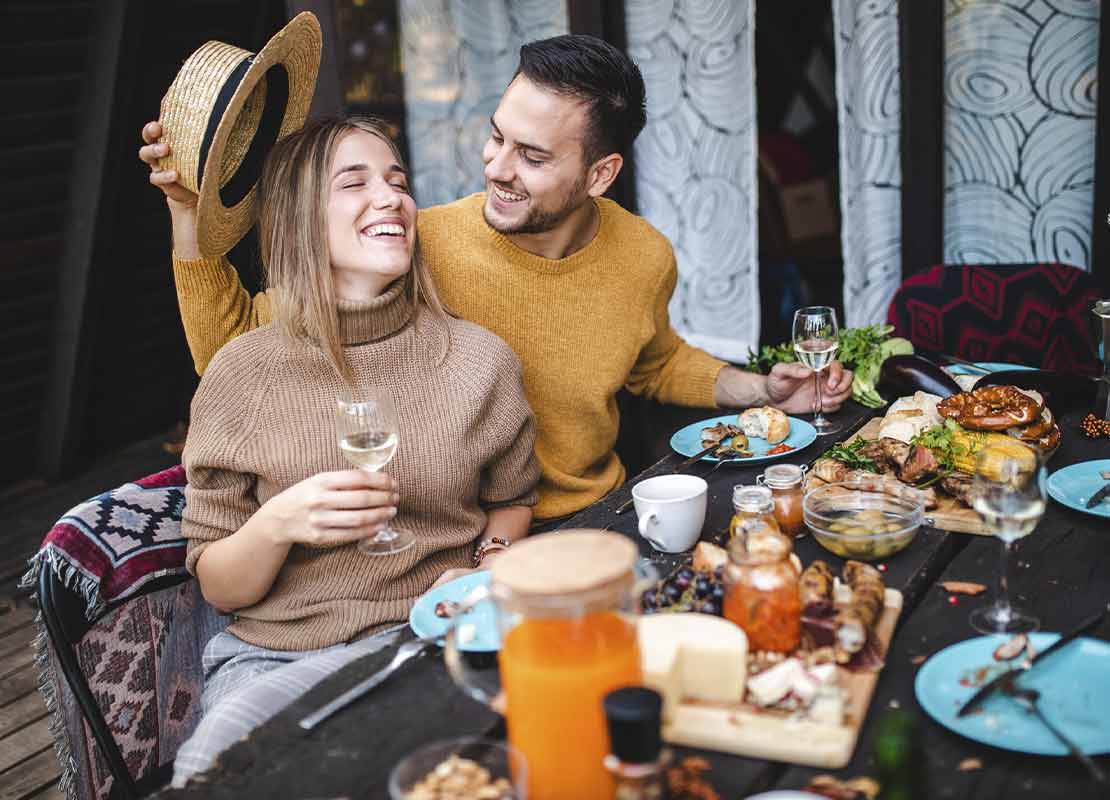 Pareja disfruta de ideas para brunch de San Valentín en un restaurante al aire libre