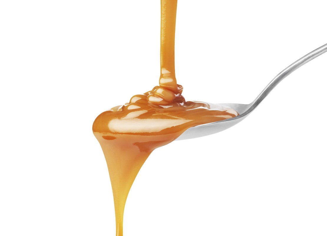 Productos lácteos como LA LECHERA® Dulce de Leche vertida sobre una cuchara