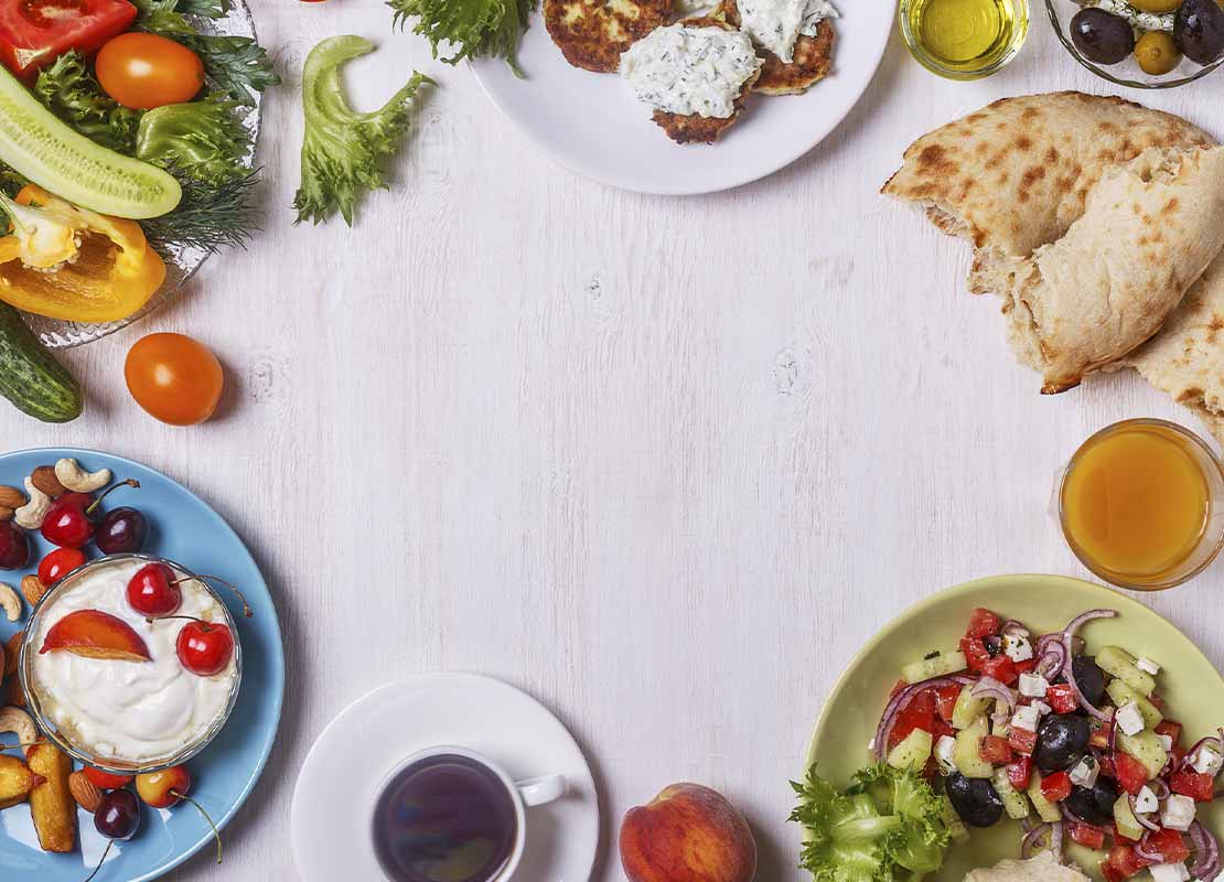 Desayuno mediterráneo con ensalada griega, yogurt, frutas, frutos secos, verduras, entre otros alimentos