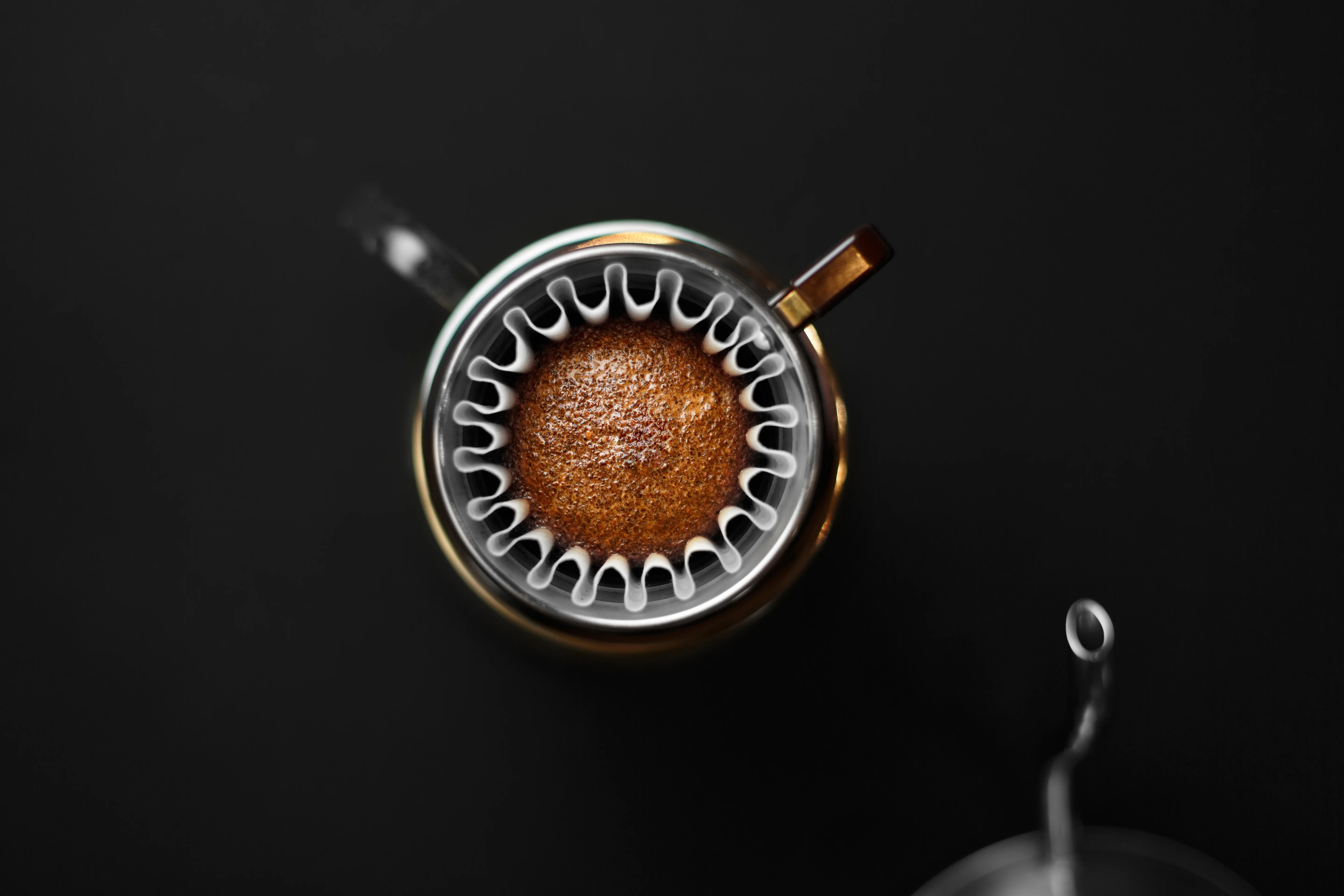 Café en una taza metálica sobre una superficie negra, resaltando su textura y color