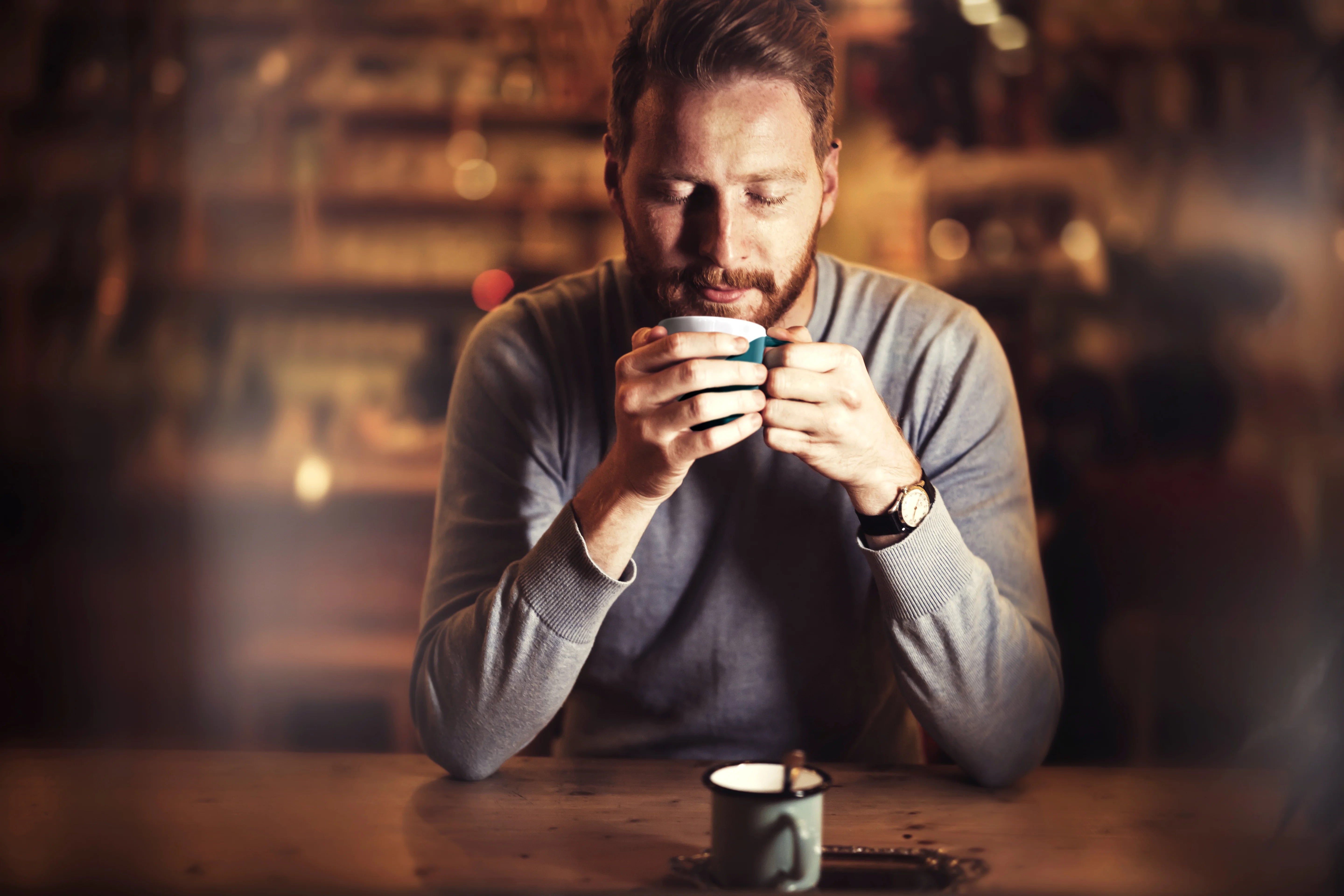 Un hombre disfruta de una taza de café en una acogedora cafetería