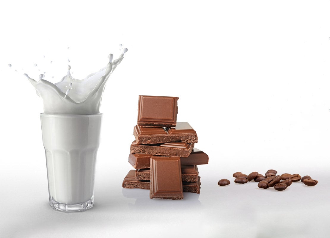 Vaso de leche, tabletas de chocolate y granos de café que son insumos de repostería de NESTLÉ PROFESSIONAL®