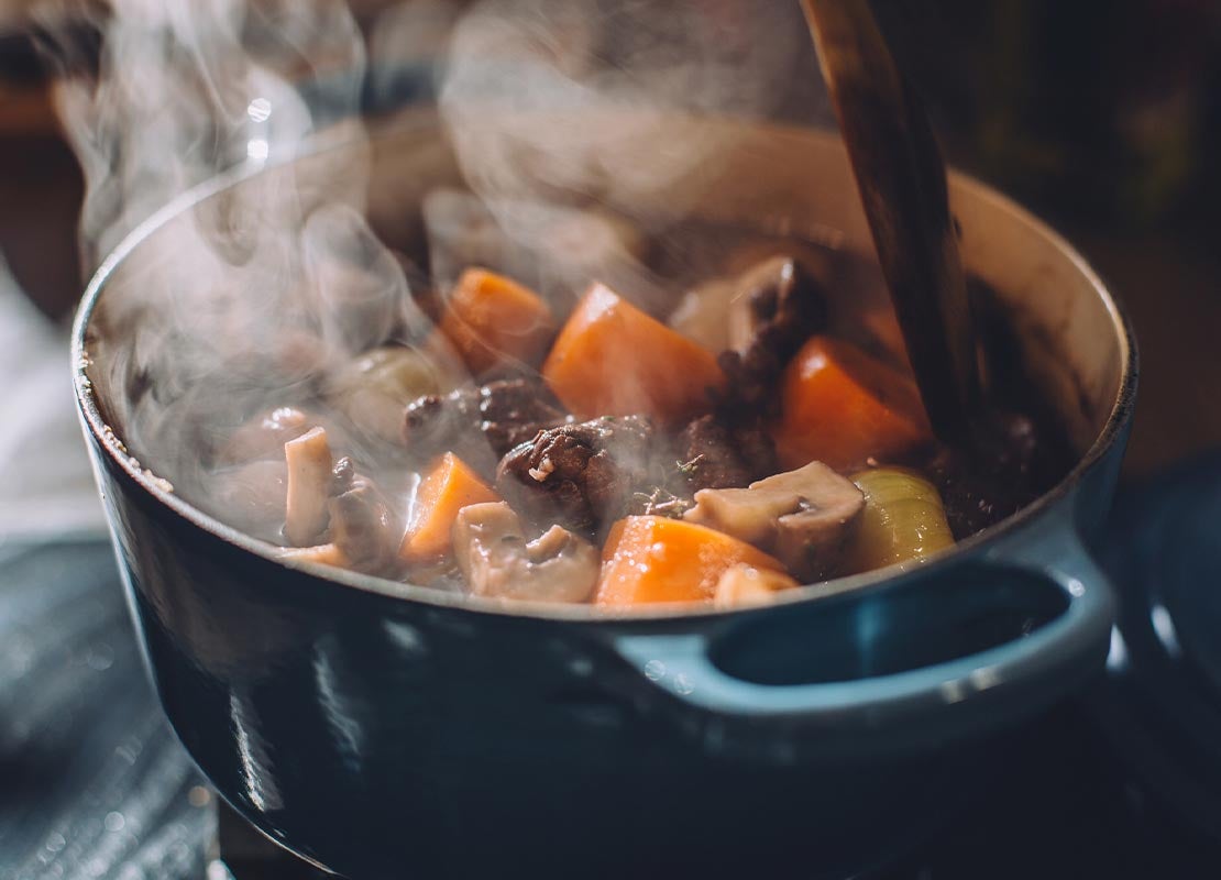 En una olla azul se hace una reducción de vegetales y carne para obtener un fondo de cocina
