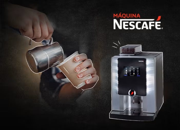 Una persona vierte leche en una taza de café junto a una elegante cafetera NESCAFÉ® sobre un fondo oscuro.