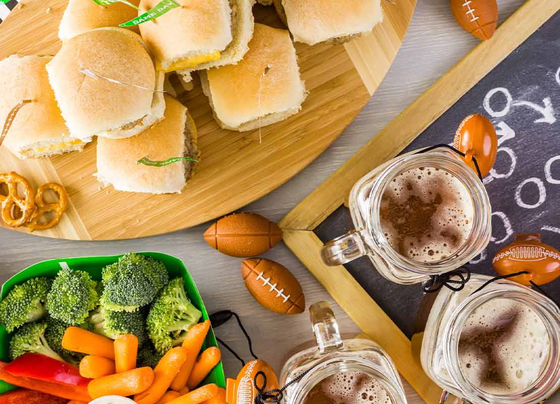 Sándwiches, vegetales como coliflor y zanahoria, bebidas, mini balones de fútbol americano y más snacks