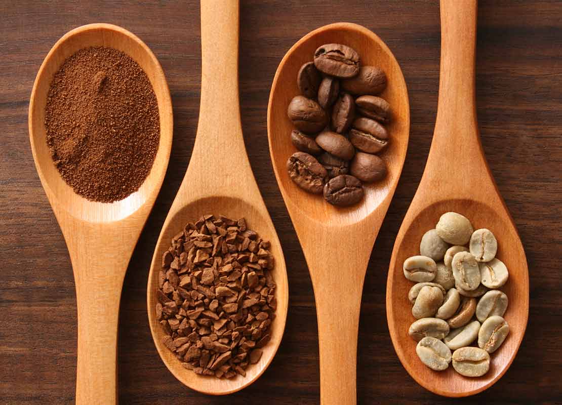 De izquierda a derecha, cucharas de madera con café soluble, molido, en grano tostado y verde