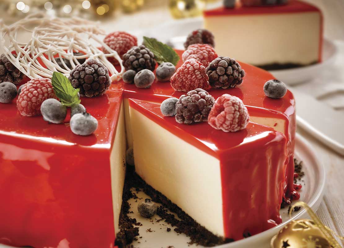 Cheesecake con glaseado tipo espejo y moras, frambuesas y arándanos liofilizados