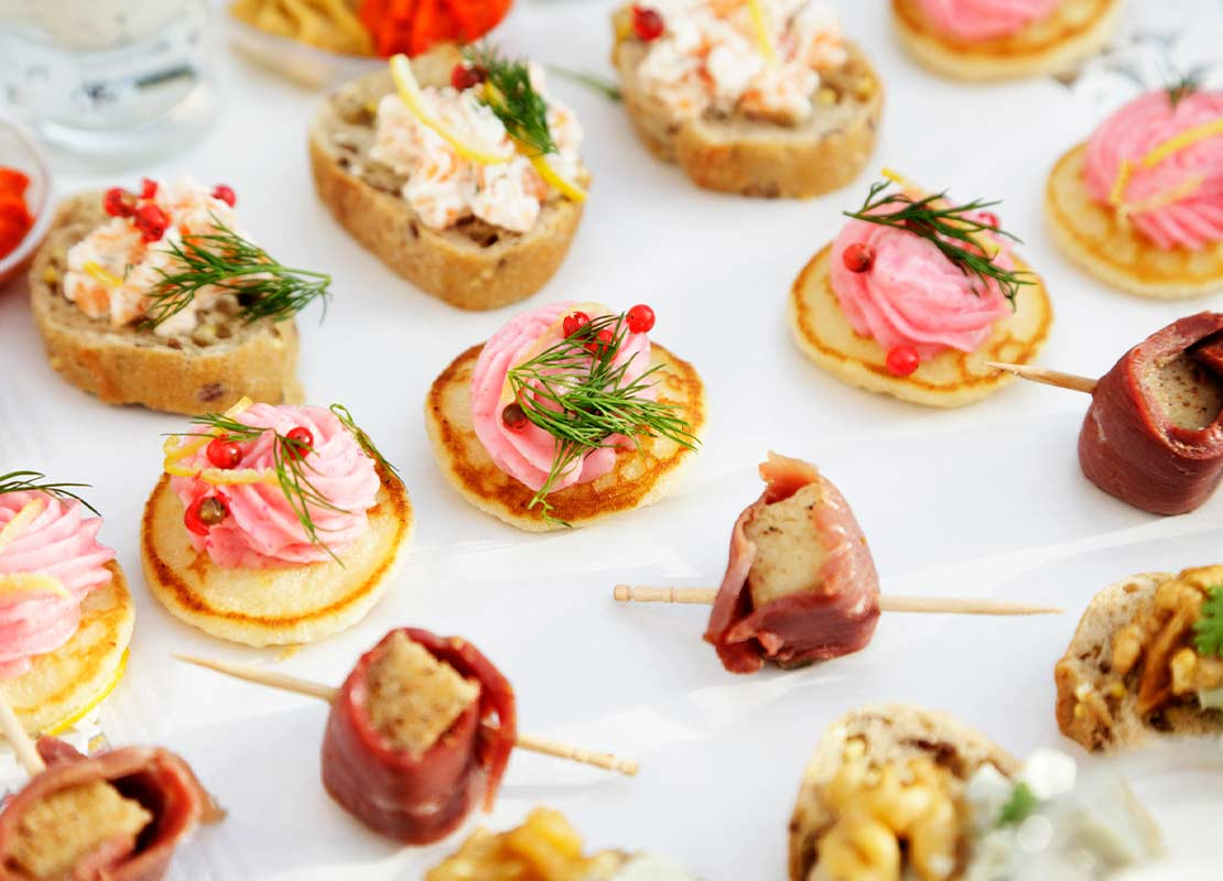 Filas de diferentes canapés, servidos sobre una bandeja en un gastrobar