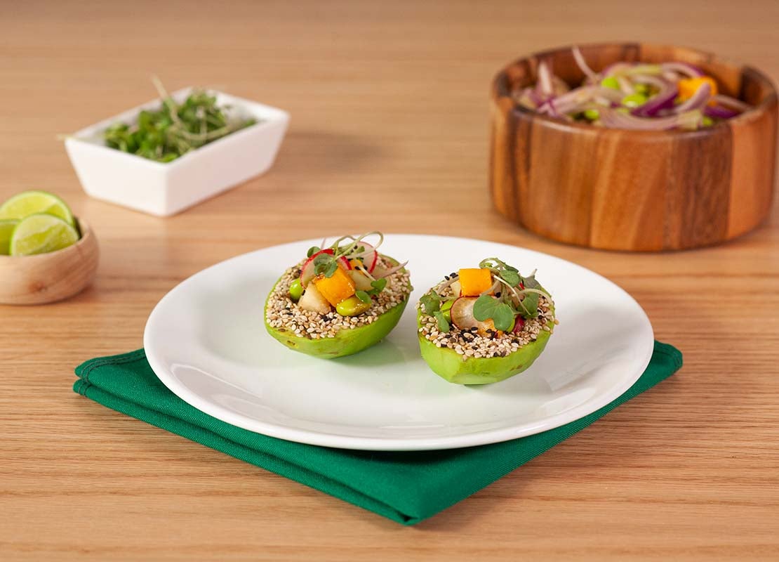 Dos tapas gourmet servidas en un plato, al lado, tazón de ensalada, rodajas de limón y cilantro