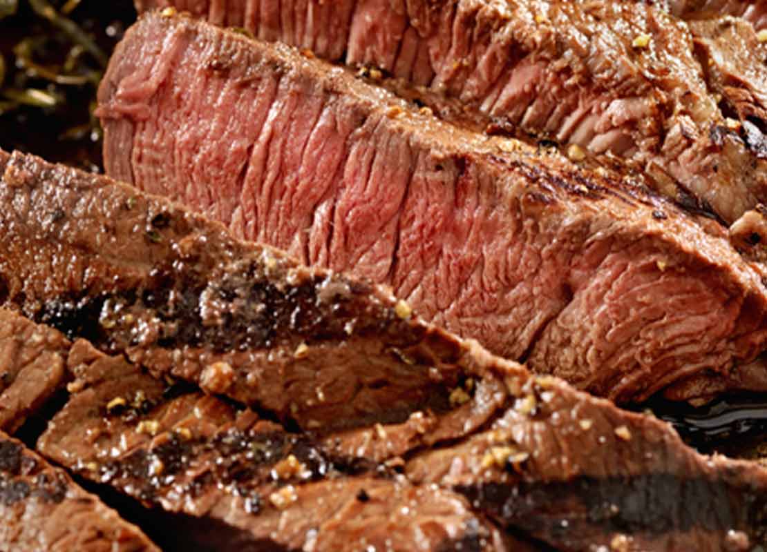 Bistec a término medio preparado con precisión, resaltando los tipos de corte en la cocina.