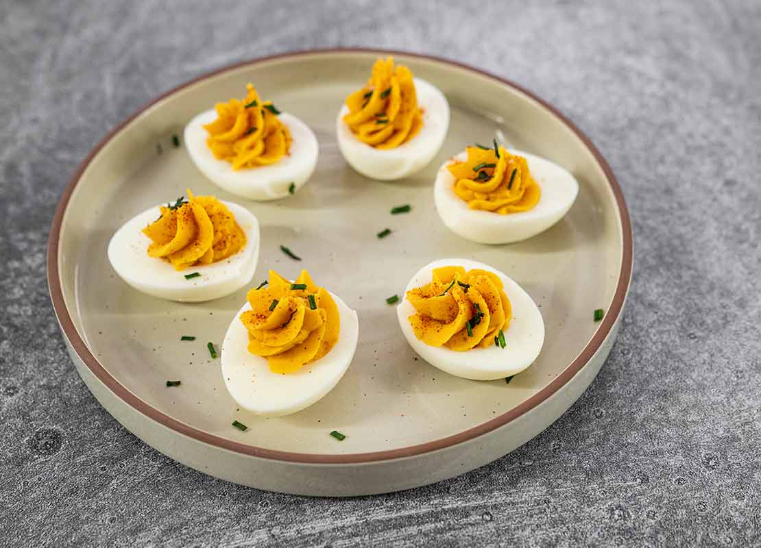 Huevos endiablados: 6 mitades de claras cocidas con una yema en forma de rosa espolvoreadas con especias