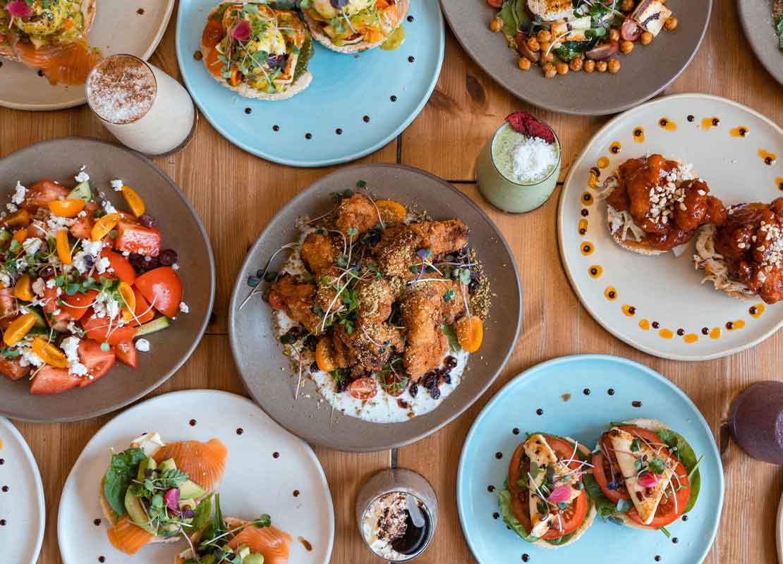 Diferentes tipos de comidas y bebidas frías y calientes servidas a la mesa, mostrando una gastronomía variada