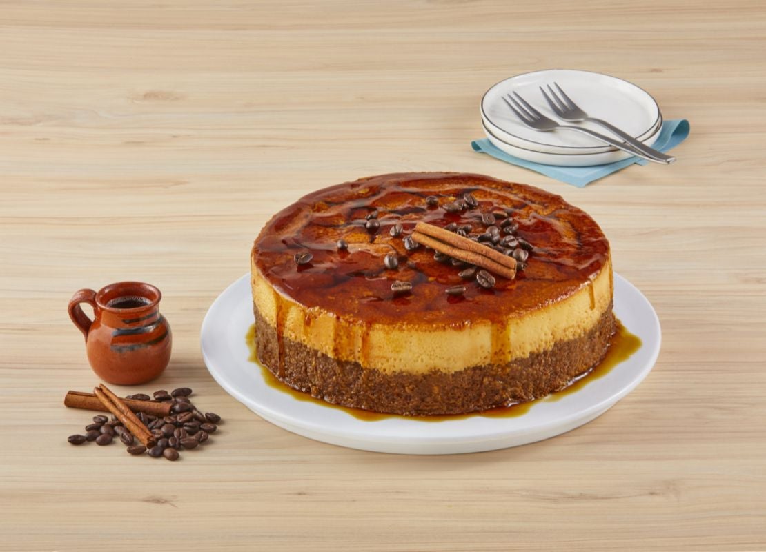 Pastel de olla servicio en un plato, decorado con café y astillas de canela, al lado jarra con café