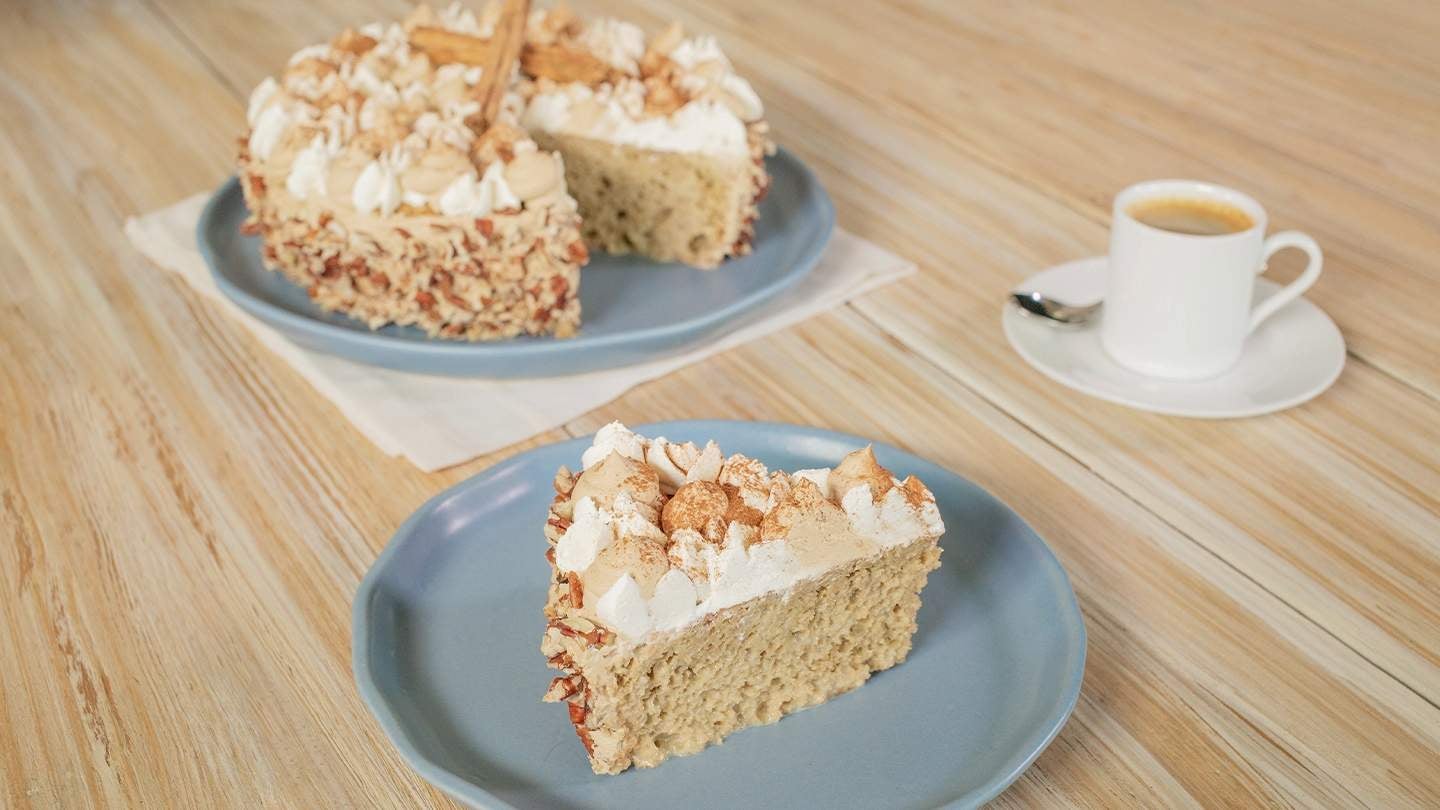 Pastel vegano decorado con crema vegetal, merengue y canela, acompañado de un café espresso
