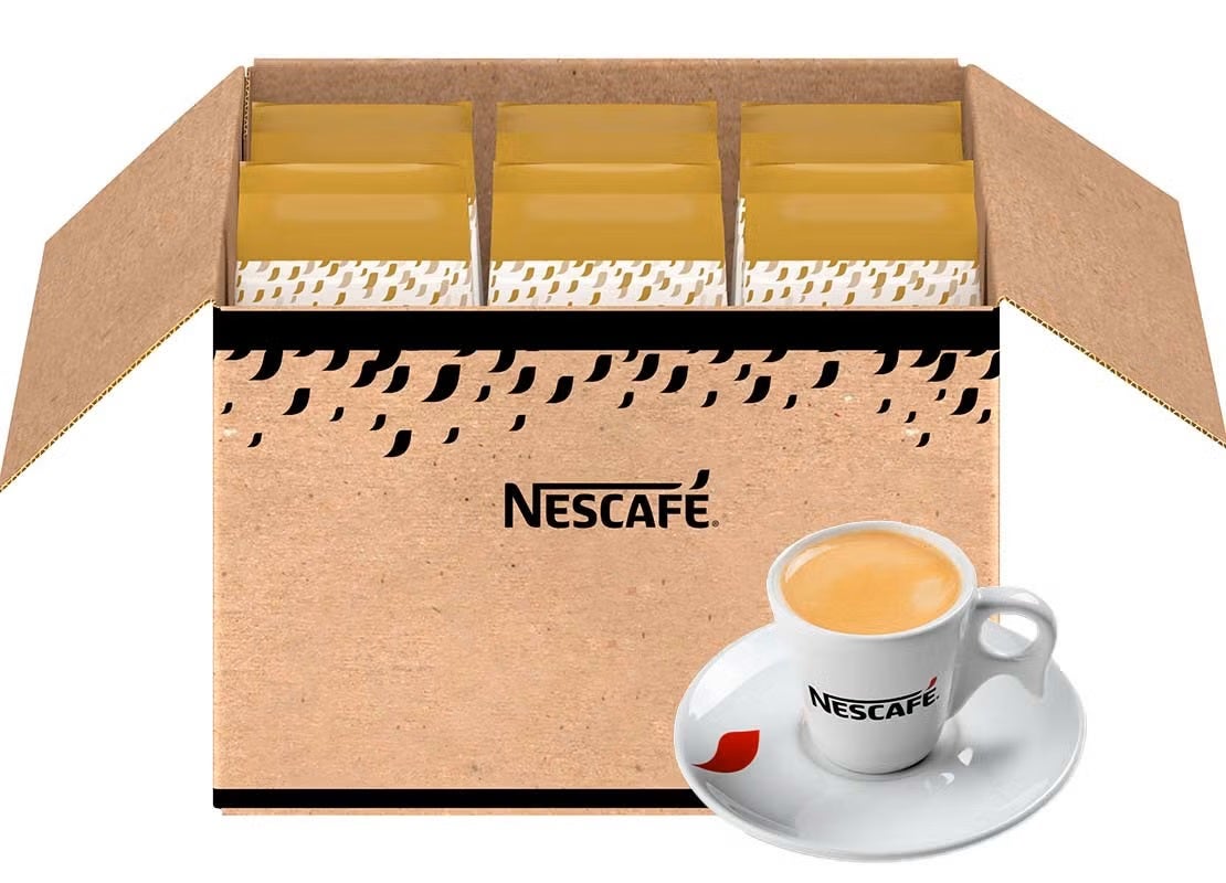 Caja con productos de NESCAFÉ®, al lado una taza de café caliente de la marca