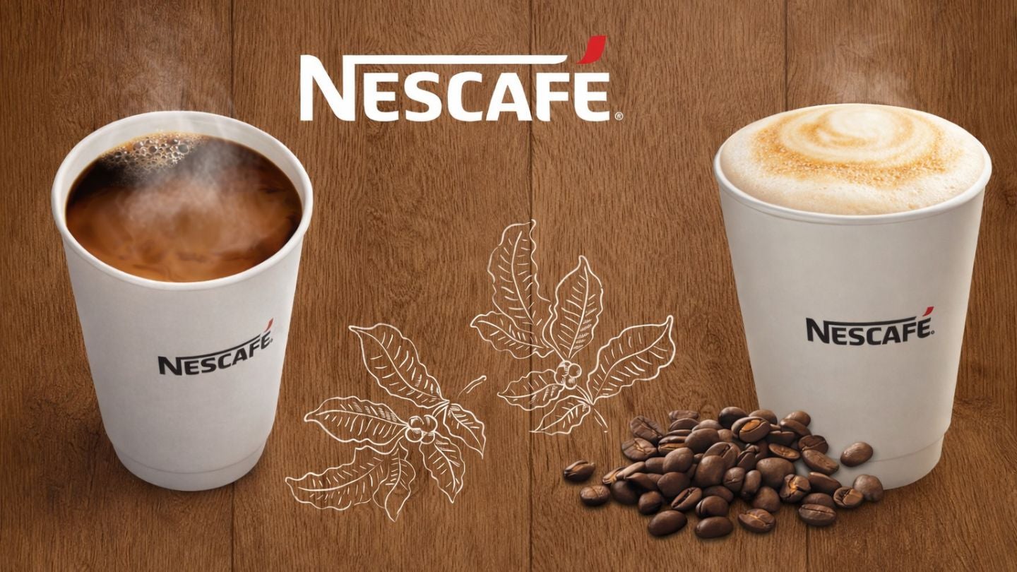 Dos vasos de NESCAFÉ con café americano y cappuccino de calidad, al pie, granos tostados