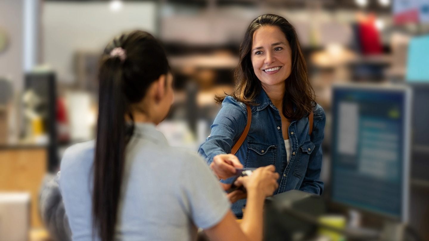 Persona realizando un pago en mostrador mientras se gestiona el arqueo de caja en un negocio gastronómico.