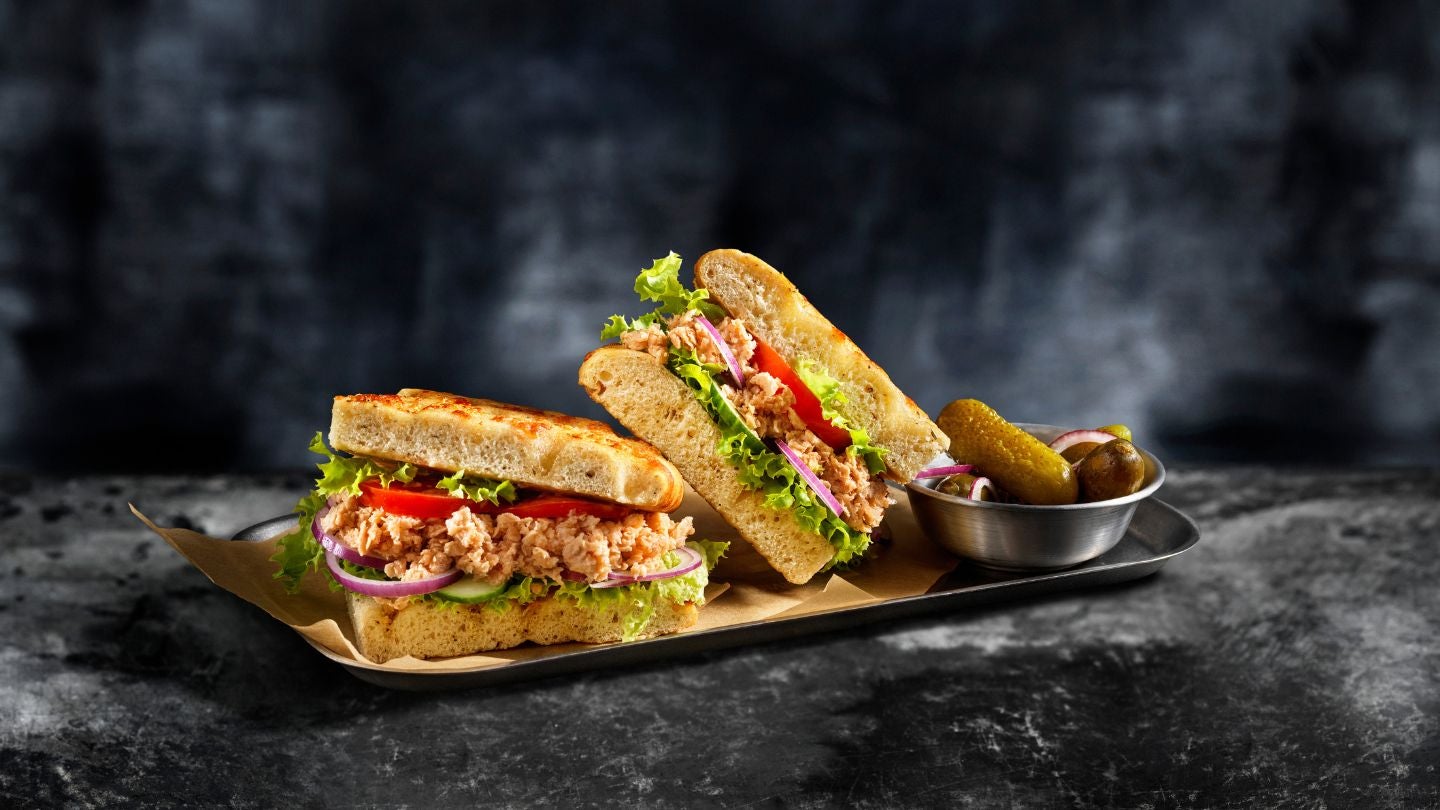 Sándwich gourmet con proteína vegetal, vegetales frescos y encurtidos, ideal para menús food service