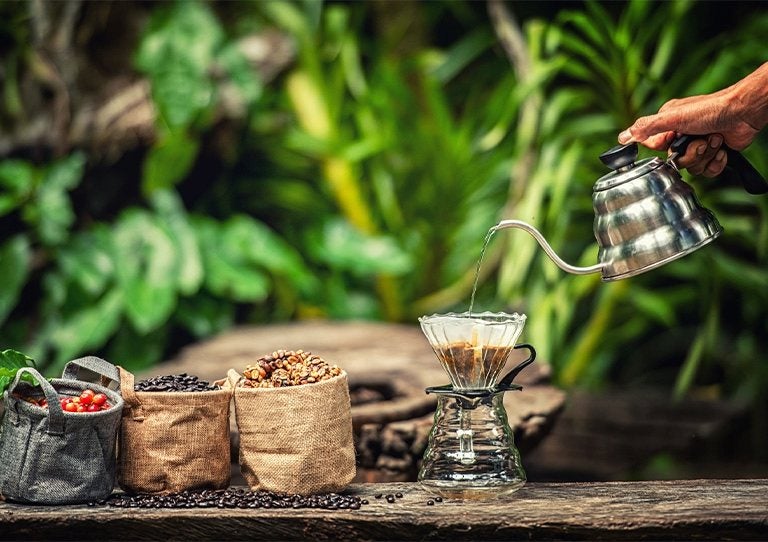 Preparación de café con método artesanal al aire libre entre granos y herramientas