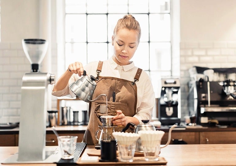 Barista preparando café con método filtrado en una estación profesional de barismo