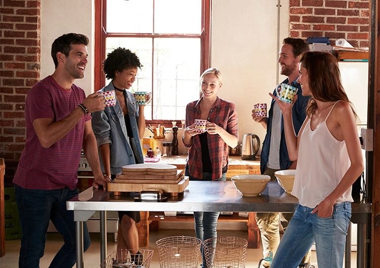 Grupo de mujeres abrazadas sonriendo al aire libre durante una actividad comunitaria